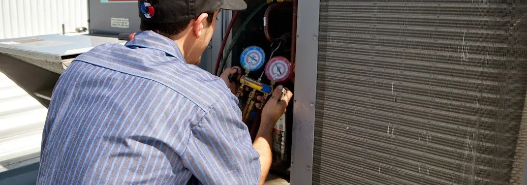 HVAC technician servicing a condenser unit in Whitney