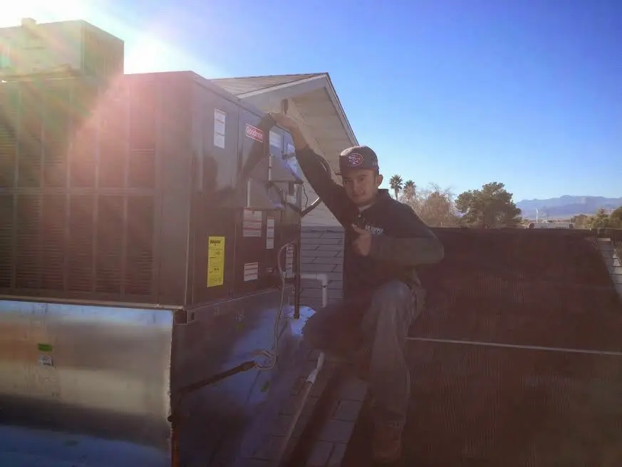 HVAC technician performing Heat Pump Repair on a rooftop unit in Whitney